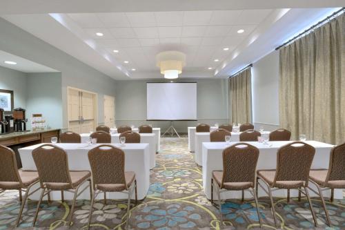 a conference room with white tables and chairs and a screen at Hilton Garden Inn Worcester in Worcester