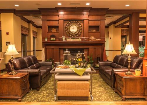 a lobby with leather furniture and a large clock at Hilton Garden Inn Bangor in Bangor