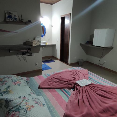 a bedroom with a bed with a pillow on the floor at Pousada Luz do Jamacá in Chapada dos Guimarães