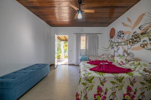 a bedroom with a bed and a blue couch at Pousada Luz do Jamacá in Chapada dos Guimarães