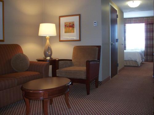 a hotel room with a couch and chairs and a table at Hilton Garden Inn Bangor in Bangor