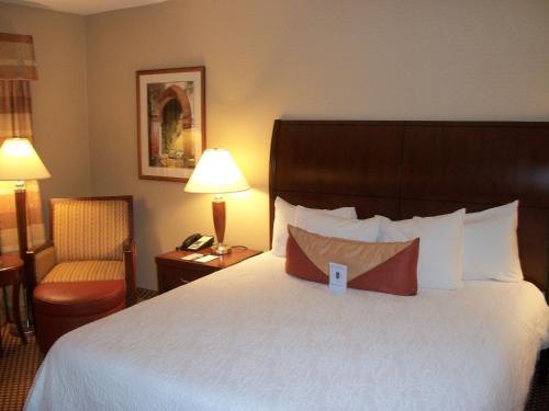 a hotel room with a large bed and a chair at Hilton Garden Inn Bangor in Bangor