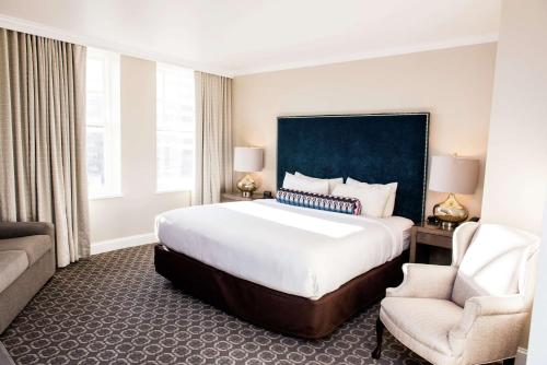 a hotel room with a large bed and a chair at Redmont Hotel Birmingham - Curio Collection by Hilton in Birmingham