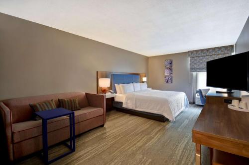 une chambre d'hôtel avec un lit et un canapé dans l'établissement Hampton Inn Birmingham-Colonnade 280, à Birmingham