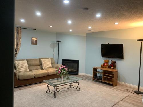 uma sala de estar com um sofá e uma televisão em Steven Abode em Calgary