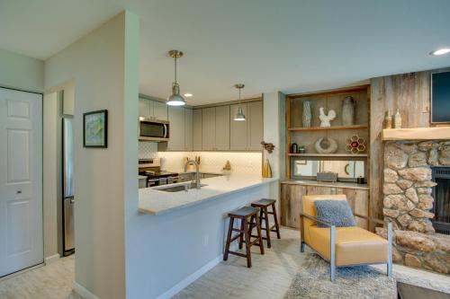 a kitchen and living room with a bar and a fireplace at Walk to Beaver Creek Shuttle! Avon Condo with Deck in Avon