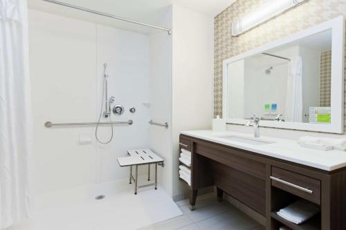 a bathroom with a sink and a shower and a mirror at Home2 Suites By Hilton Birmingham Colonnade in Birmingham