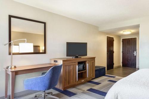 a hotel room with a desk and a television at Hampton Inn Birmingham-Trussville in Trussville