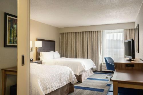 a hotel room with two beds and a television at Hampton Inn Birmingham-Trussville in Trussville