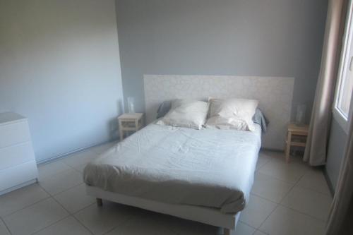 a bedroom with a bed with white sheets and pillows at Maison Au Milieu De La Foret in Labastide-Rouairoux