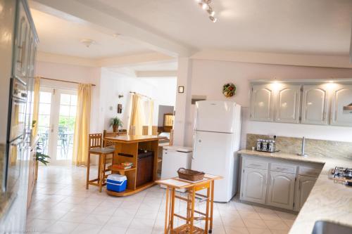 a kitchen with a white refrigerator and a table at Castles In Paradise Villa Resort in Vieux Fort