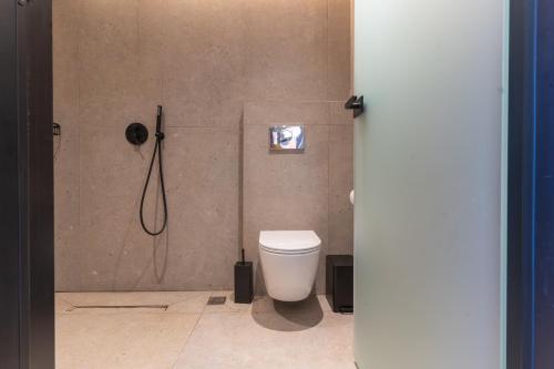 a bathroom with a toilet and a shower at La Casita Bali Crete in Balíon