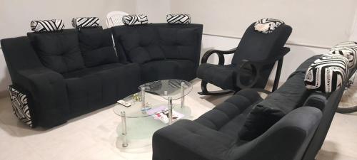 uma sala de estar com dois sofás pretos e uma mesa em FINCA SAN JUAN - SUTATENZA em Sutatenza