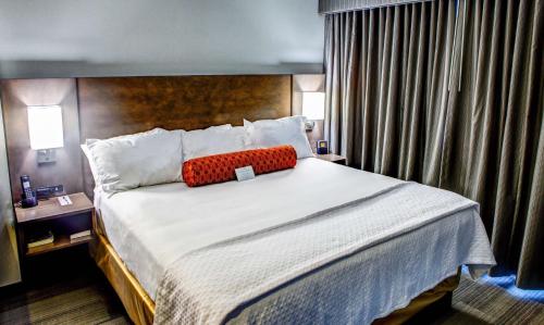 a bedroom with a large bed with a red pillow on it at DoubleTree by Hilton West Fargo Sanford Medical Center Area in Fargo