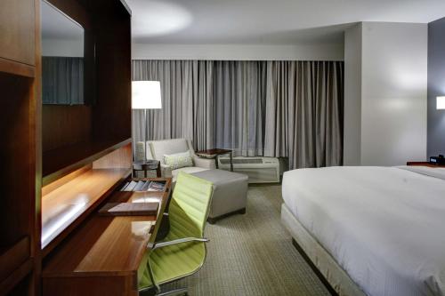 a hotel room with a bed and a desk and a bed and a chair at DoubleTree by Hilton Biloxi in Biloxi