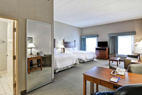 Habitación de hotel con 2 camas y espejo en Hampton Inn Bloomsburg, en Bloomsburg