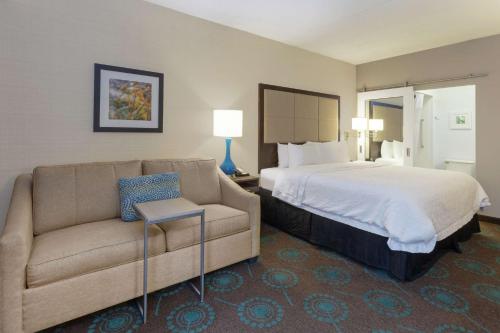 Habitación de hotel con cama y sofá en Hampton Inn Bloomington en Bloomington