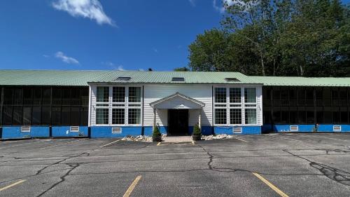 um edifício azul e branco com estacionamento em Travelodge by Wyndham Lincoln Near White Mountain em Lincoln