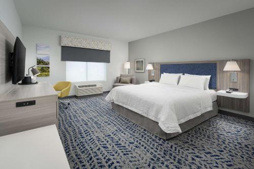 Ashland CityにあるHampton Inn Ashland City, Tnの大型ベッドとテレビが備わるホテルルームです。