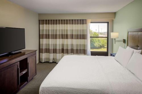 a hotel room with a bed and a flat screen tv at Hampton Inn & Suites Nashville-Airport in Nashville