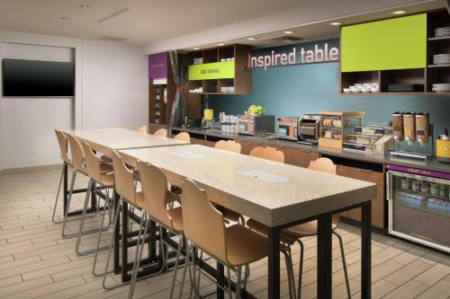 a cafeteria with a long table and chairs in a restaurant at Home2 Suites by Hilton Nashville Franklin Cool Springs in Franklin