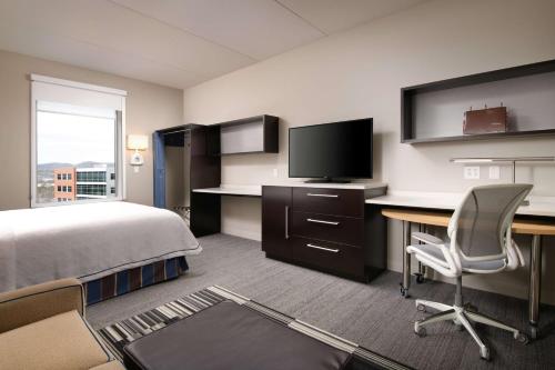 a hotel room with a bed and a desk and a tv at Home2 Suites by Hilton Nashville Franklin Cool Springs in Franklin