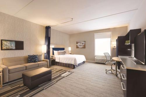 a hotel room with a bed and a couch at Home2 Suites by Hilton Nashville Franklin Cool Springs in Franklin
