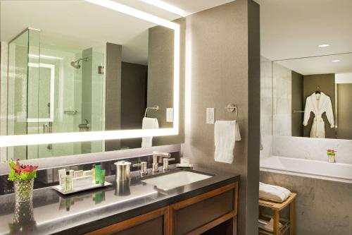 a bathroom with a sink and a large mirror at Hilton Nashville Downtown in Nashville