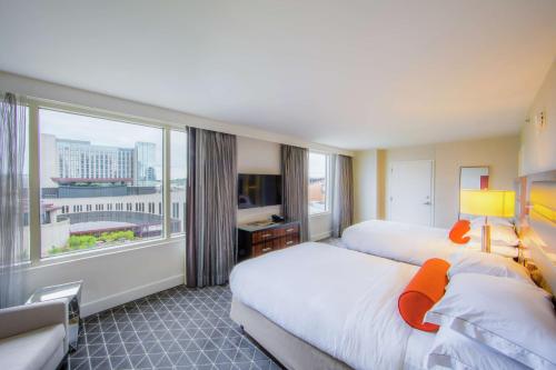 a hotel room with two beds and a large window at Hilton Nashville Downtown in Nashville