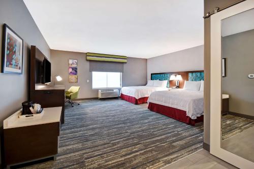 a hotel room with two beds and a television at Hampton Inn Pleasant View in Pleasant View