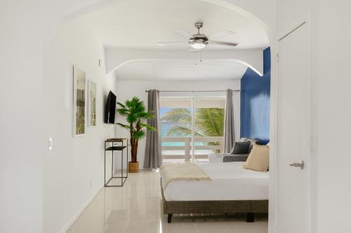 a bedroom with a bed and a view of the ocean at CocoVaa Beach Boutique Hotel in Simpson Bay
