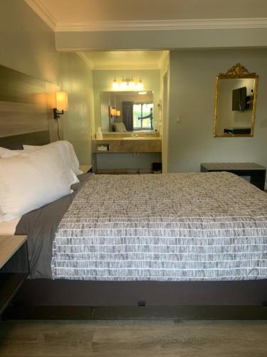 a bedroom with a large bed and a mirror at Monterey Oceanside Inn in Monterey
