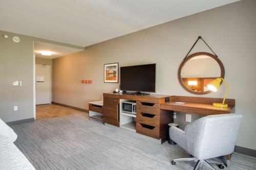 a bedroom with a desk with a television and a mirror at Hampton Inn & Suites by Hilton Nashville North Skyline in Nashville