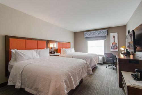 a hotel room with two beds and a desk at Hampton Inn & Suites by Hilton Nashville North Skyline in Nashville