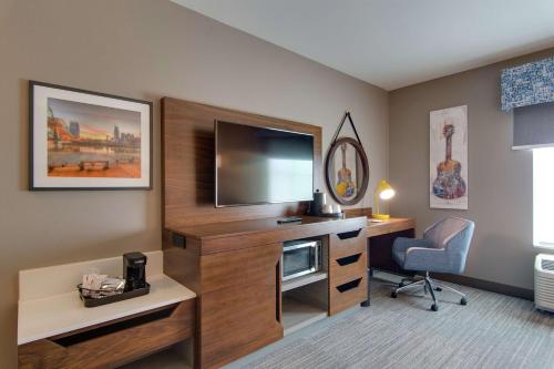 a hotel room with a tv and a desk with a chair at Hampton Inn & Suites by Hilton Nashville North Skyline in Nashville