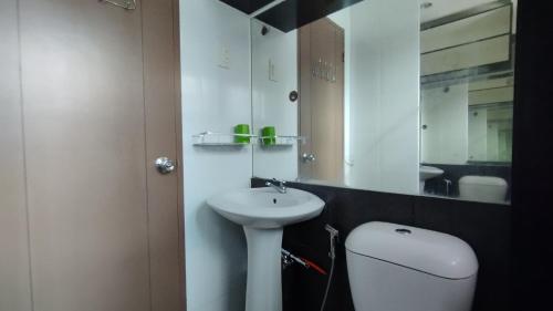 a bathroom with a sink and a toilet and a mirror at 2 Bedroom House in Bambu Estates Mintal Near Vista Mall and UP Mindanao in Davao City
