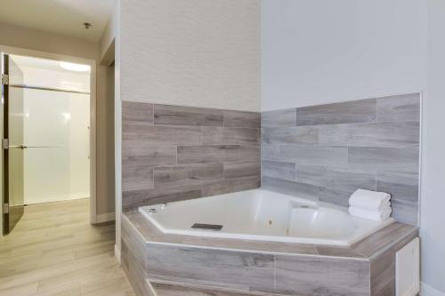 a bath tub in a bathroom with gray tiles at Hampton Inn White House in White House