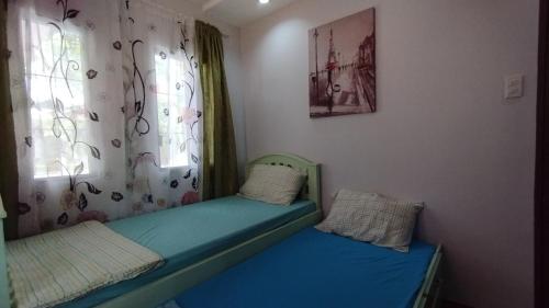 1 dormitorio con 2 camas en una habitación con ventana en 2 Bedroom House in Bambu Estates Mintal Near Vista Mall and UP Mindanao en Dávao