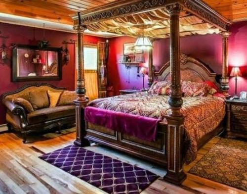 Southwoods Mountain Estate -private mansion, pool, hottub+ 15 acres في مونتايسلو: غرفة نوم مع سرير مظلة وأريكة