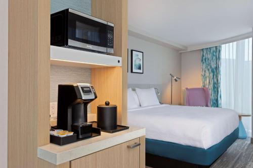 a hotel room with a bed and a tv at Hilton Garden Inn Boston Brookline, Ma in Brookline