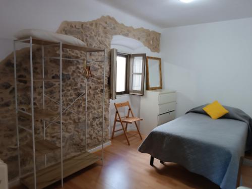 a bedroom with a bed and a stone wall at Apartamento en Terrades, Empordà in Terrades