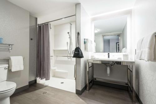雀兒喜的住宿－切爾西波士頓洛根機場希爾頓惠庭套房酒店，白色的浴室设有水槽和卫生间。
