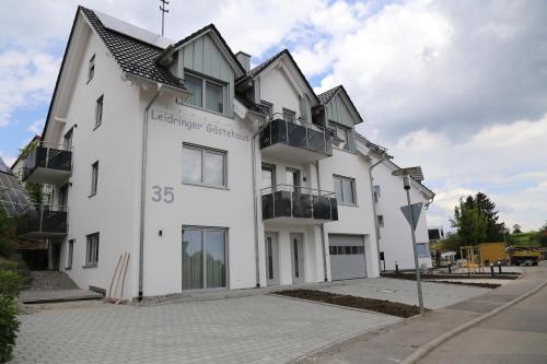 a white building with windows on a street at Leidringer Gästehaus GmbH in Rosenfeld