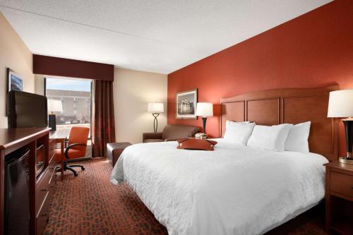 um quarto de hotel com uma cama grande e uma televisão em Hampton Inn Boston/Braintree em Braintree