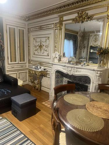 a living room with a table and a fireplace at Cozy Nice Apartment Room Free Wi-Fi an parking in Asnières-sur-Seine