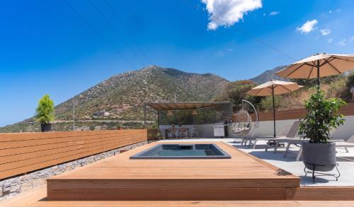 a patio with a pool with a mountain in the background at La Casita Bali Crete in Balíon