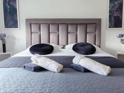a bed with four pillows on top of it at Green Harmony Apartment in Pale