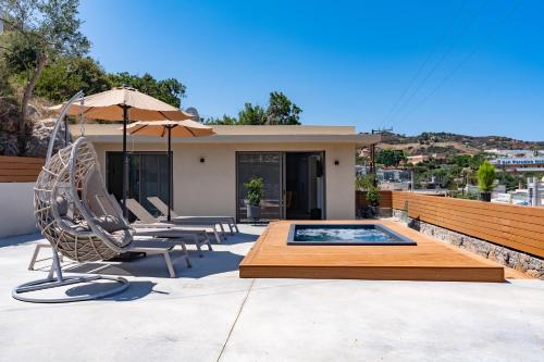 a patio with a hot tub and chairs and an umbrella at La Casita Bali Crete in Balíon