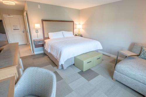 a hotel room with a bed and a chair at Hampton Inn by Hilton Amesbury, MA in Amesbury