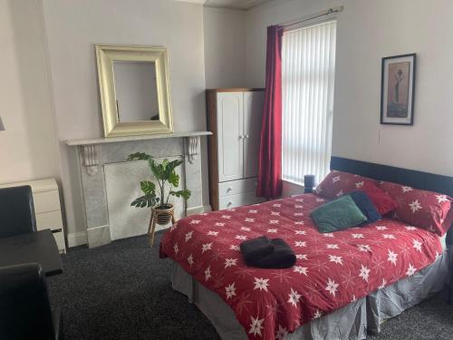 1 dormitorio con 1 cama con manta roja y espejo en bnb, en Belfast